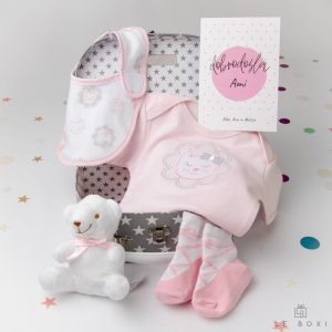 Siv darilni kovček z belimi zvezdicami vsebuje bombažni roza komplet z motivom muce z bodijem, slinčkom in nogavičkami iz mehkega bombaža ter plišastim medvedkom