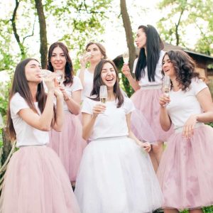 Praznovanje dekliščine, ženske oblečene v roza obleke nazdravljajo s penino